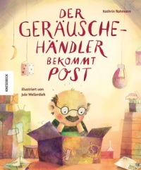 Ein Mann mit Brille blickt in einen Karton, der auf einem Tisch steht.