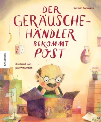 Ein Mann mit Brille blickt in einen Karton, der auf einem Tisch steht.