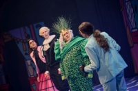 Mehrere Menschen in bunten Kostümen auf einer Theaterbühne