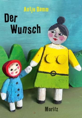 Das Buchcover zeigt ein Mädchen und seine Großmutter, die sich an der Hand halten. Die Figuren sind aus Holz geschnitzt und mit Acrylfarbe bemalt.
