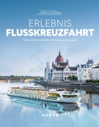 Ein Fluss mit einem Flusskreuzfahrtschiff vor einer Stadtansicht mit Brücke