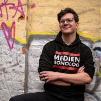 Ein Porträtfoto des Interviewteilnehmers, der ein schwarzes Sweatshirt trägt.