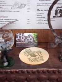 Ein Weinglas, ein Biedeckel und eine Speisekarte