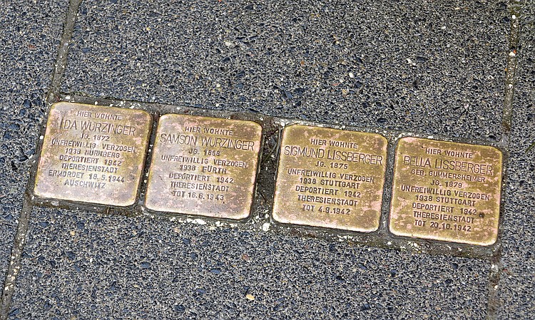 Quadratische Bronzeplaketten im Straßenasphalt