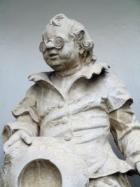 Eine Steinstatue, die einen Mann mit Brille zeigt