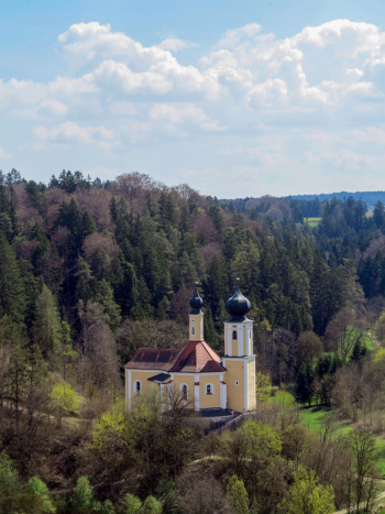 Einen kleine Kapelle mit Zwiebelturm in einem dichten Wald