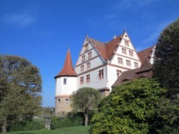 Ein kleineis Schloss steht in einer Parkanlage