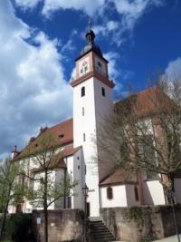 Ein Kirche mit eckigem Turm unter blauem Himmel