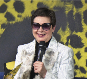 Eine Frau mit Sonnenbrille und Mikrofonin der Hand