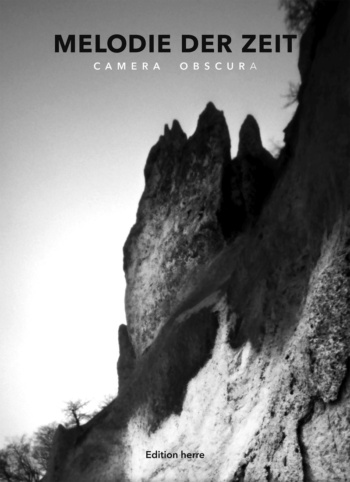 Ein großer Felsen, an dessen Fuß Bäume wachsen