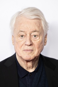 Ein Porträtfoto von Alexander Kluge mit weißen Haaren und schwarzem Anzug