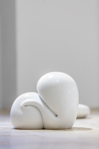 Eine kleine weiße Porzellanfigur, die einem Tropfen ähnelt.