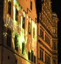 Die angestrahlte Fassade eines altertümlichen Hauses.