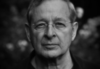 Ein schwarz-weiß Porträtfoto des Autors, der eine schmale Brille trägt.