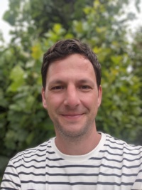 Ein Porträtfoto des Interviewteilnehmers im gestreiften Shirt