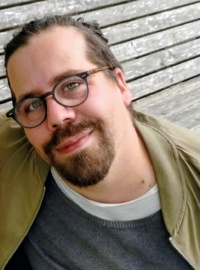 Foto eines jungen Mannes mit Bart und Brille