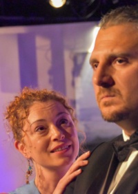 Ein Mann und eine Frau in schicker Kleidung auf einer Theaterbühne