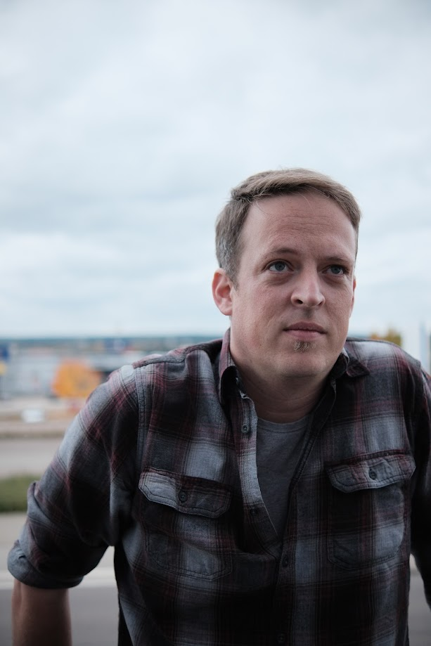 Ein Foto des Autors in einem karierten Hemd